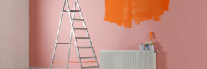 Stepladder and painting tools near wall in empty room