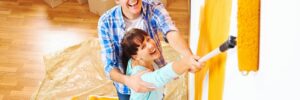 young couple painting walls of their home