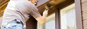 man painting exterior of home