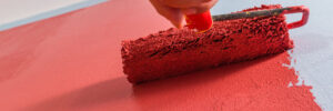 a close-up of someone painting a wall with a roller