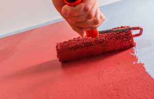 a close-up of someone painting a wall with a roller