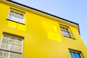 Part of the exterior of a yellow townhouse