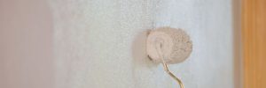 Paint roller painting wall white