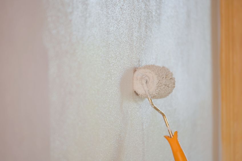 Paint roller painting wall white